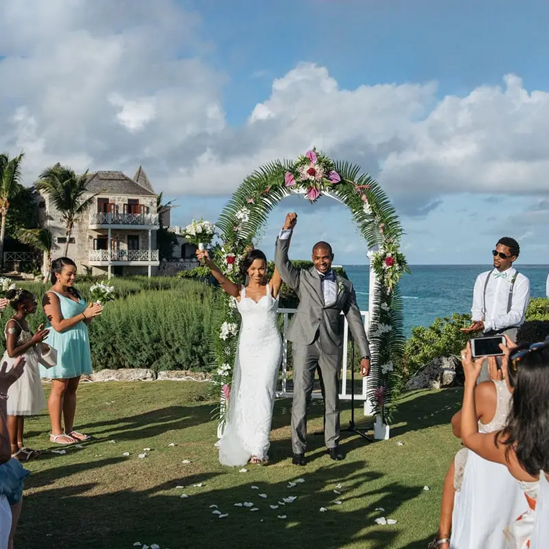 A couple gets married under a tropical altar in the gardens of the Crane in Barbados