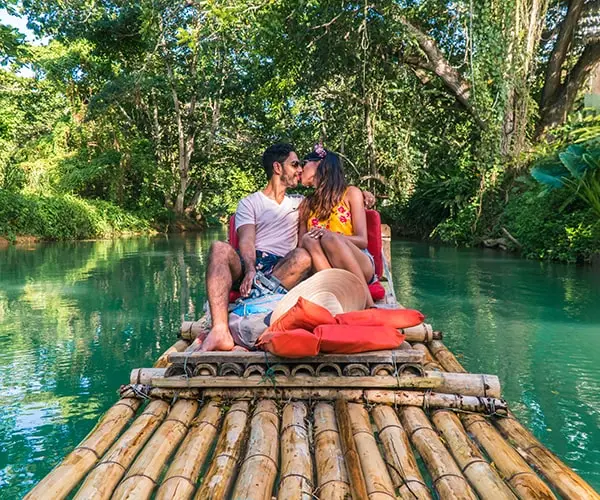 Couple kissing on a bamboo raft in Jamaica