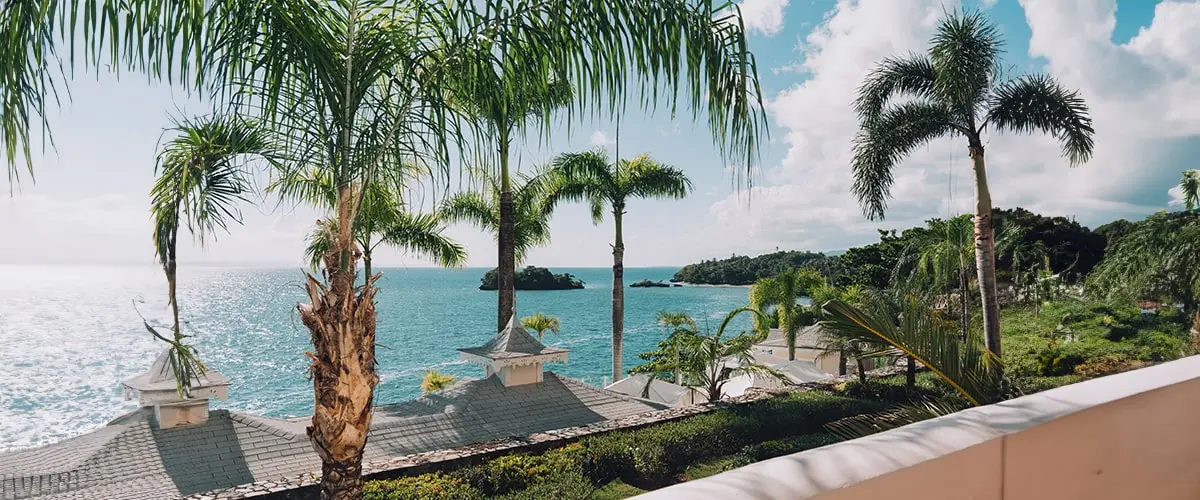 Charming buildings and palm trees frame a look out to the waters in Samana