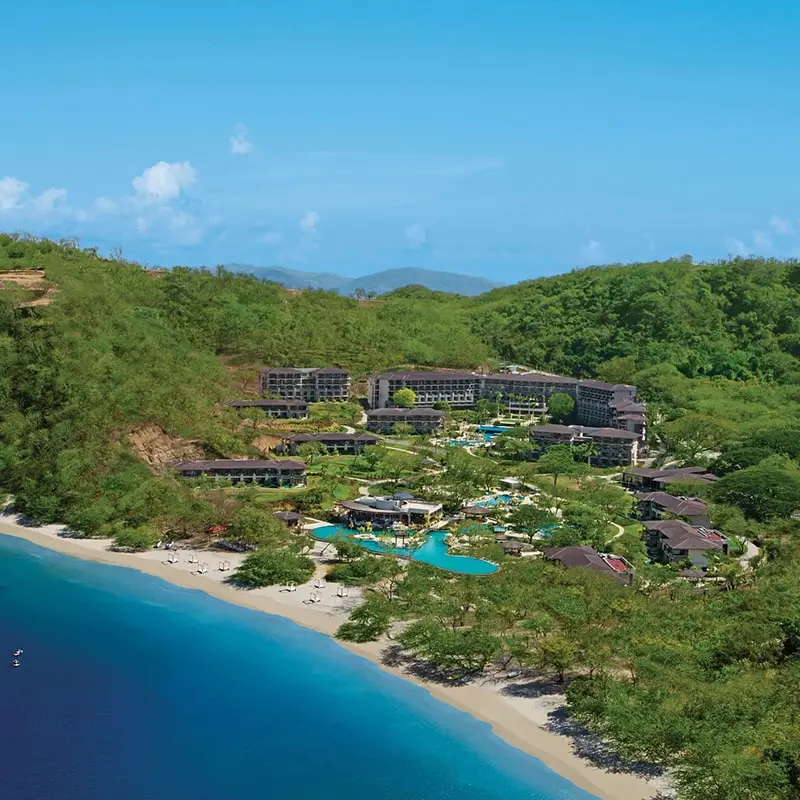 A drone view of Dreams Las Mareas resort nestled in jungle on the coastline of Costa Rica.