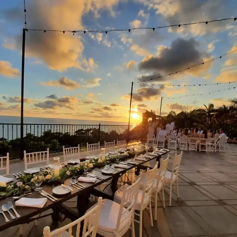 A wedding reception at sunset with tables laid out and guests gathering at Parador Nature Resort.
