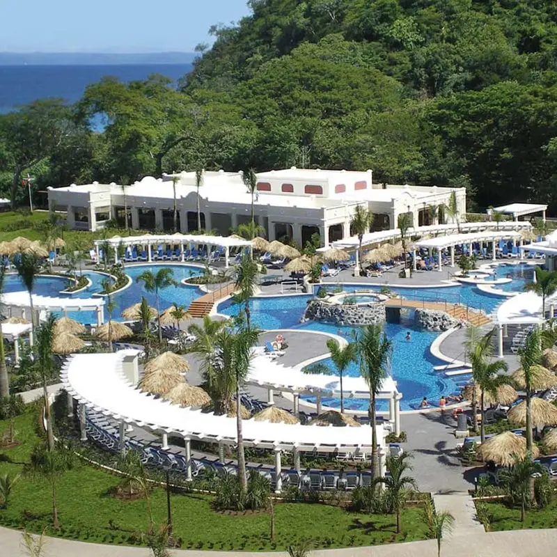 An overview of the Hotel Riu Guanacaste with pools, white buildings, and a jungle setting.