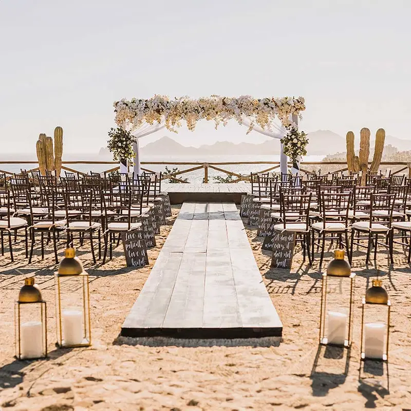 A beach wedding in Los Cabos with cactus framing the flower-adorned altar.