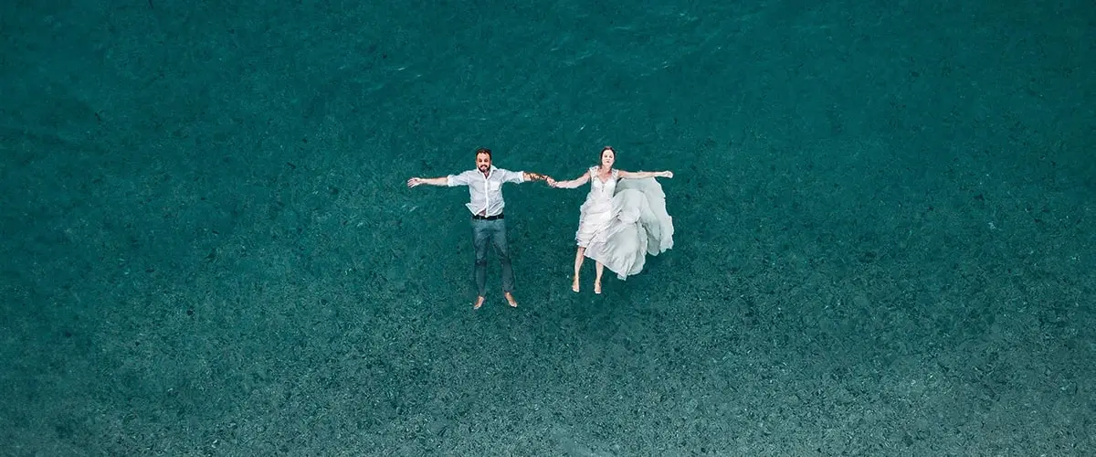 A couple relaxes in the water thanks to their destination wedding checklist
